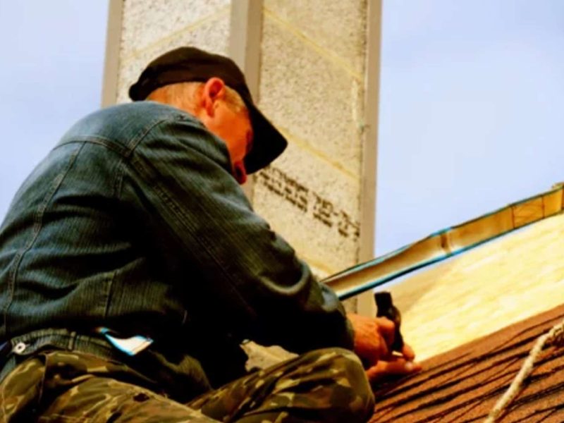 Roofer repairing shingles on a residential roof in Fultondale, Alabama