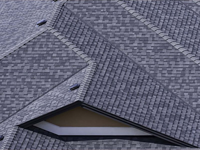 Close-up of a newly installed shingle roof with intersecting rooflines and flashing.