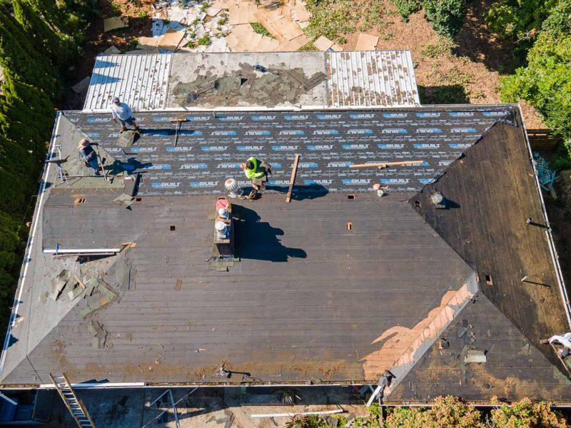 Roof replacement workers install underlayment on a residential home in Homewood, Alabama.